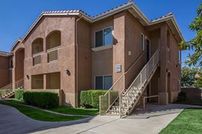 Victorville apartment for rent - A two-story apartment building with a staircase leading to the second floor.