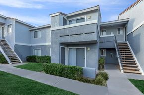 Barstow apartment for rent - A modern two-story house with a grey exterior and a staircase leading to the upper level.