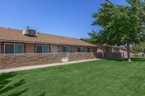 Hesperia apartment for rent - A house with a green lawn and a tree in front.