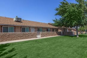 Hesperia apartment for rent - A house with a green lawn and a tree in front.