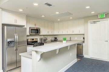 Novato apartment for rent - A kitchen with white cabinets and a stainless steel refrigerator.