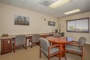 Victorville apartment for rent - A conference room with a table, chairs, and a painting on the wall.
