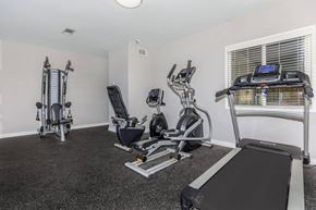 Barstow apartment for rent - A well-equipped home gym with a treadmill, stationary bike, and weight machine.