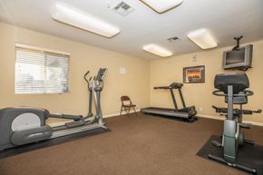 Barstow apartment for rent - A home gym with a treadmill, elliptical trainer, and a stationary bike.