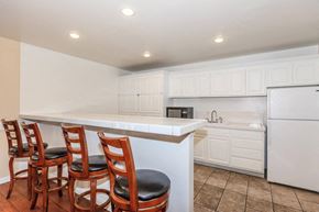 Vista apartment for rent - A kitchen with white cabinets and a white fridge.