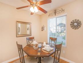 Orange apartment for rent - a dining room with a table and chairs and a ceiling fan