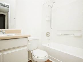 Palm Springs apartment for rent - A white bathroom with a toilet, sink, and bathtub.