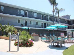 Pico Rivera apartment for rent - A leasing office is located in front of a pool and palm trees.