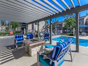 Santa Ana apartment for rent - A poolside area with blue and white striped lounge chairs.