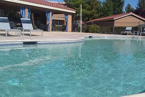 Hesperia apartment for rent - a swimming pool with chairs and a house in the background