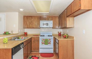 Barstow apartment for rent - A kitchen with wooden cabinets and a white oven.