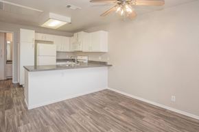 Victorville apartment for rent - A kitchen with white cabinets and a wooden floor.