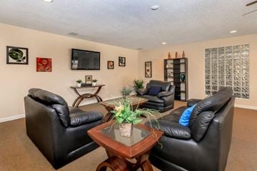Hesperia apartment for rent - A living room with black leather couches and a wooden coffee table.