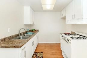 Hesperia apartment for rent - A kitchen with white cabinets and a granite countertop.