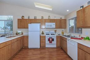 Victorville apartment for rent - A kitchen with wooden cabinets and white appliances.