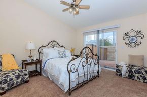 Victorville apartment for rent - A bedroom with a large bed and a ceiling fan.