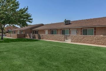 Hesperia apartment for rent - A building with a brown roof and a green lawn in front.
