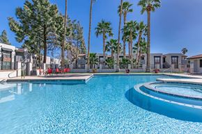 Phoenix apartment for rent - a large swimming pool with palm trees and apartments in the background