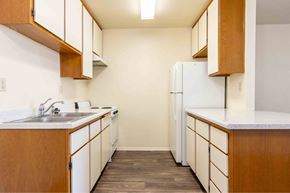 Victorville apartment for rent - a kitchen with white cabinets and a sink and a refrigerator