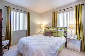 Victorville apartment for rent - a bedroom with a bed and two windows with curtains