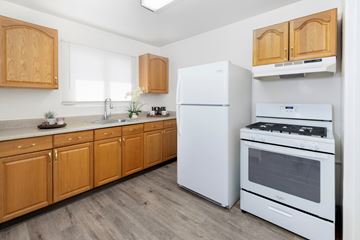 San Jose apartment for rent - A kitchen with wooden cabinets and white appliances.
