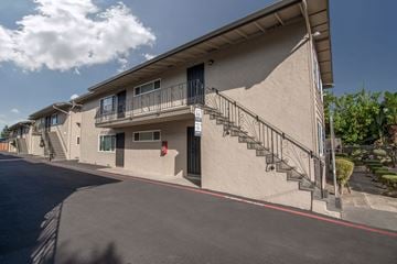San Jose apartment for rent - a building with a staircase and a street in front of it