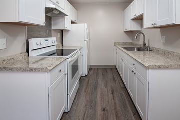 San Jose apartment for rent - an all white kitchen with marble counter tops and white cabinets