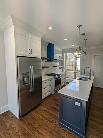 Chicago apartment for rent - a kitchen with white cabinets and a stainless steel refrigerator
