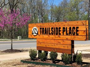 Bentonville apartment for rent - A wooden sign that says Trailside Place in front of a tree.