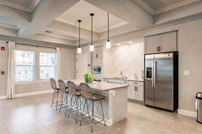 Cape Coral apartment for rent - community kitchen with a chairs, a bar, and appliances at Vantage Luxury Apartments in  Cape Coral, FL