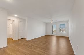 Houston apartment for rent - A room with wooden floors and a ceiling fan.