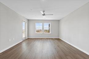 San Marcos apartment for rent - A spacious room with a ceiling fan and two windows.
