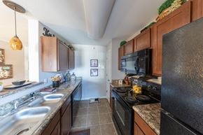 Michigan City apartment for rent - A kitchen with a black stove top oven and a black microwave.