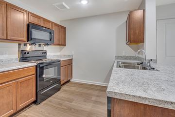 Houston apartment for rent - A kitchen with wooden cabinets and a black oven.