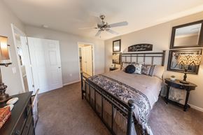 Michigan City apartment for rent - A bedroom with a large bed and a ceiling fan.
