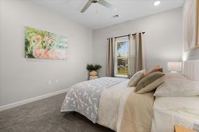 Fort Myers apartment for rent - A bedroom with a large bed and a painting of flamingos on the wall.