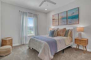 Palm Bay apartment for rent - A bedroom with a large bed and a painting of a beach scene on the wall.
