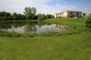 Kalamazoo apartment for rent - a small pond in front of apartment buildings at Canterbury Apartments in Kalamazoo, MI