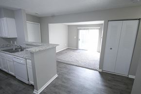 Logansport apartment for rent - Kitchen and an empty living room with a door to a patio.
