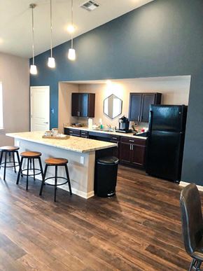 New Albany apartment for rent - A kitchen with a black refrigerator and wooden floors.