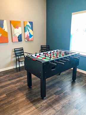 New Albany apartment for rent - A foosball table in a small room with pictures on the wall
