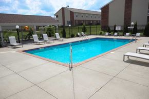 Michigan City apartment for rent - A large swimming pool surrounded by a black fence and lounge chairs.