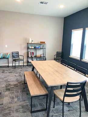 New Albany apartment for rent - A room with a table, chairs, and a bookshelf.