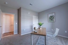 Grove City apartment for rent - Adesk with a chair in a room with a door to a hallway at Crossing at Grove City apartments in Grove City, OH