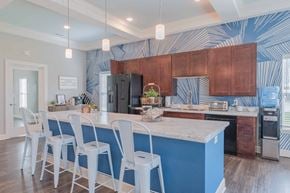 Grove City apartment for rent - Community kitchen with a bar and chairs with dark wood cabinets and black appliances