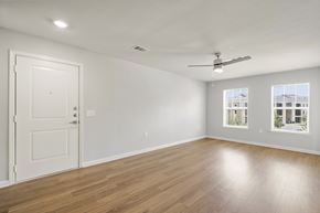 Del Valle apartment for rent - A room with a white door, a ceiling fan, and a window showing a building outside.