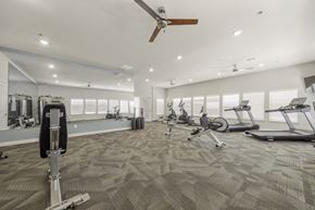 Del Valle apartment for rent - A spacious gym with a variety of exercise equipment and a ceiling fan.