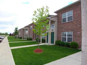 Warsaw apartment for rent - an apartment building with green grass and a tree in front at canterbury house apartments in warsaw