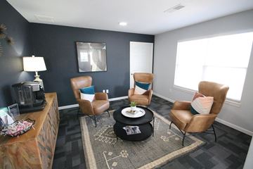 Kokomo apartment for rent - A living room with a brown chair and a black coffee table.