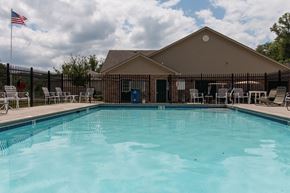 Southgate apartment for rent - A pool in front of a building with a flag on the left.